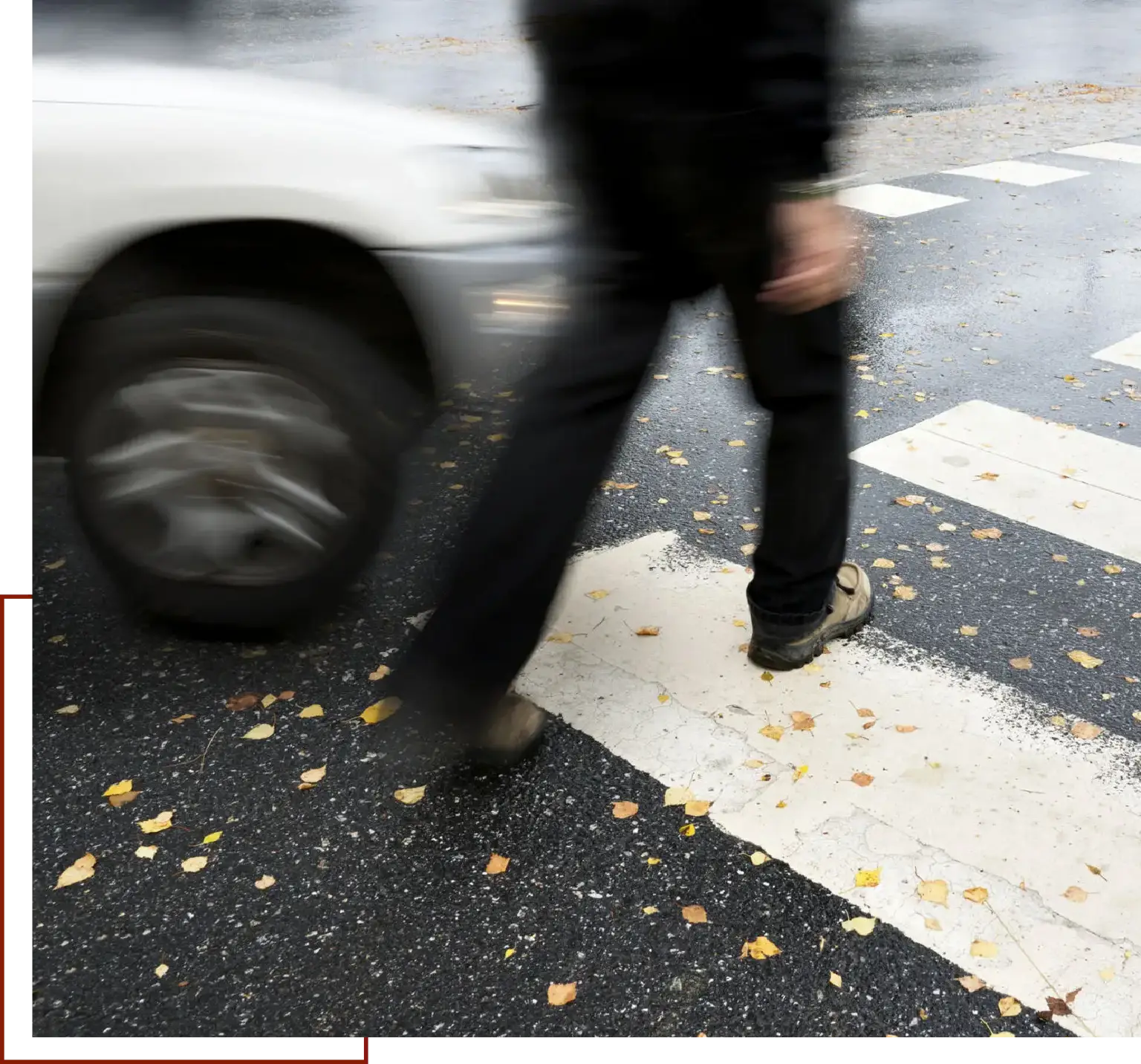 Man walking across a crosswalk with a car in the background