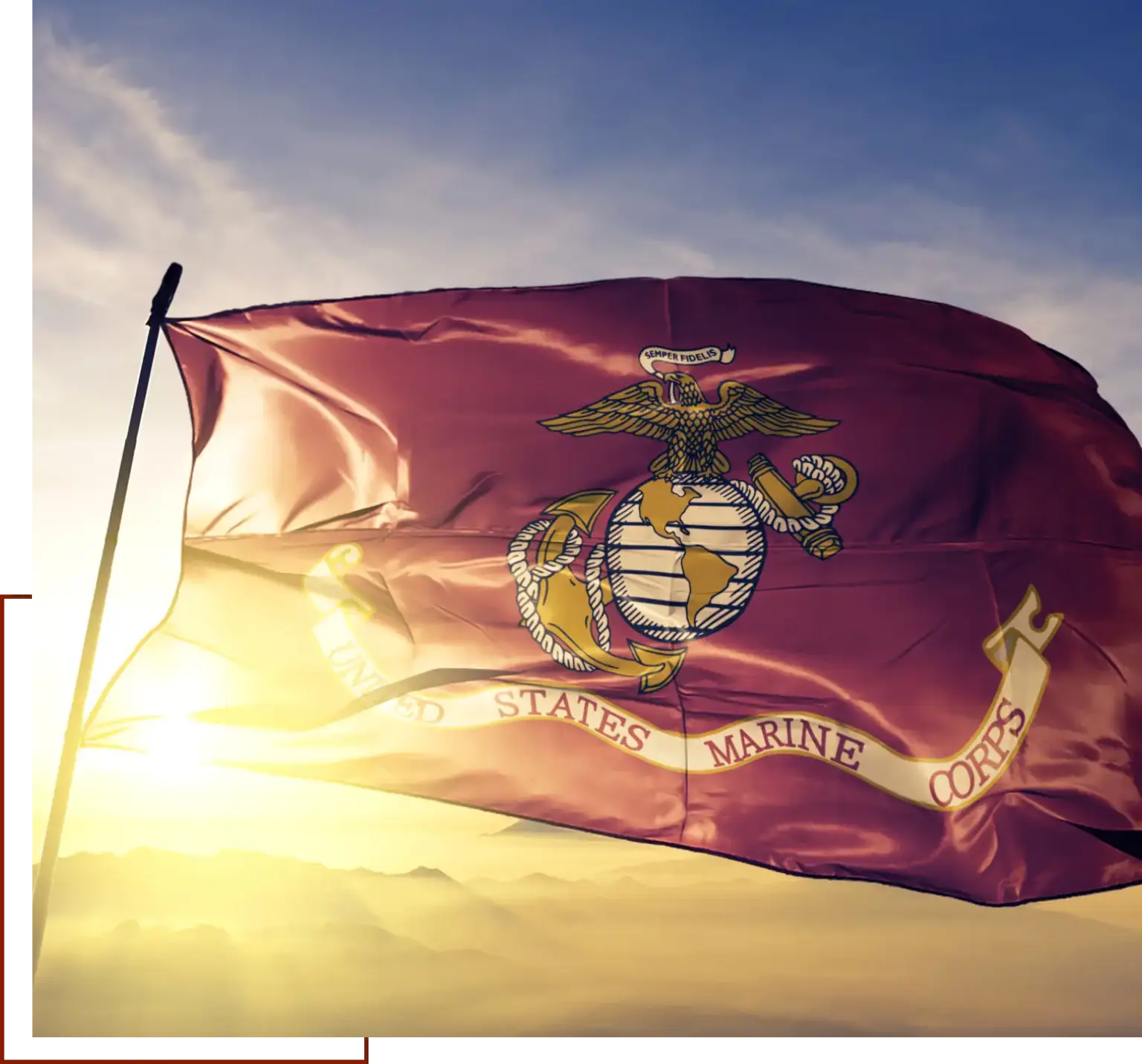 Maroon flag with the US emblem flying high in the sky, with a pole in the foreground