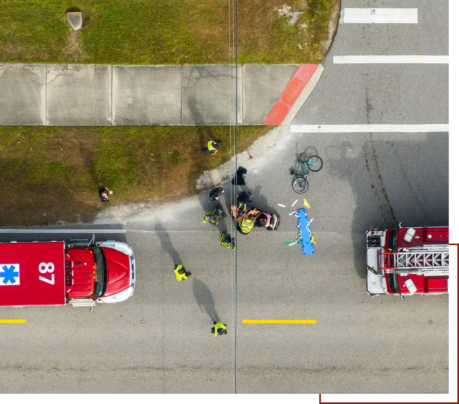 Aerial view of a fire truck parked on the side of the road, with a bicycle and a car nearby
